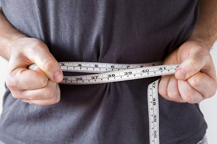 曼测量他的腰围尺寸用卷尺。