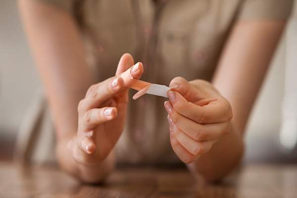 女人把一个绷带在她的手指