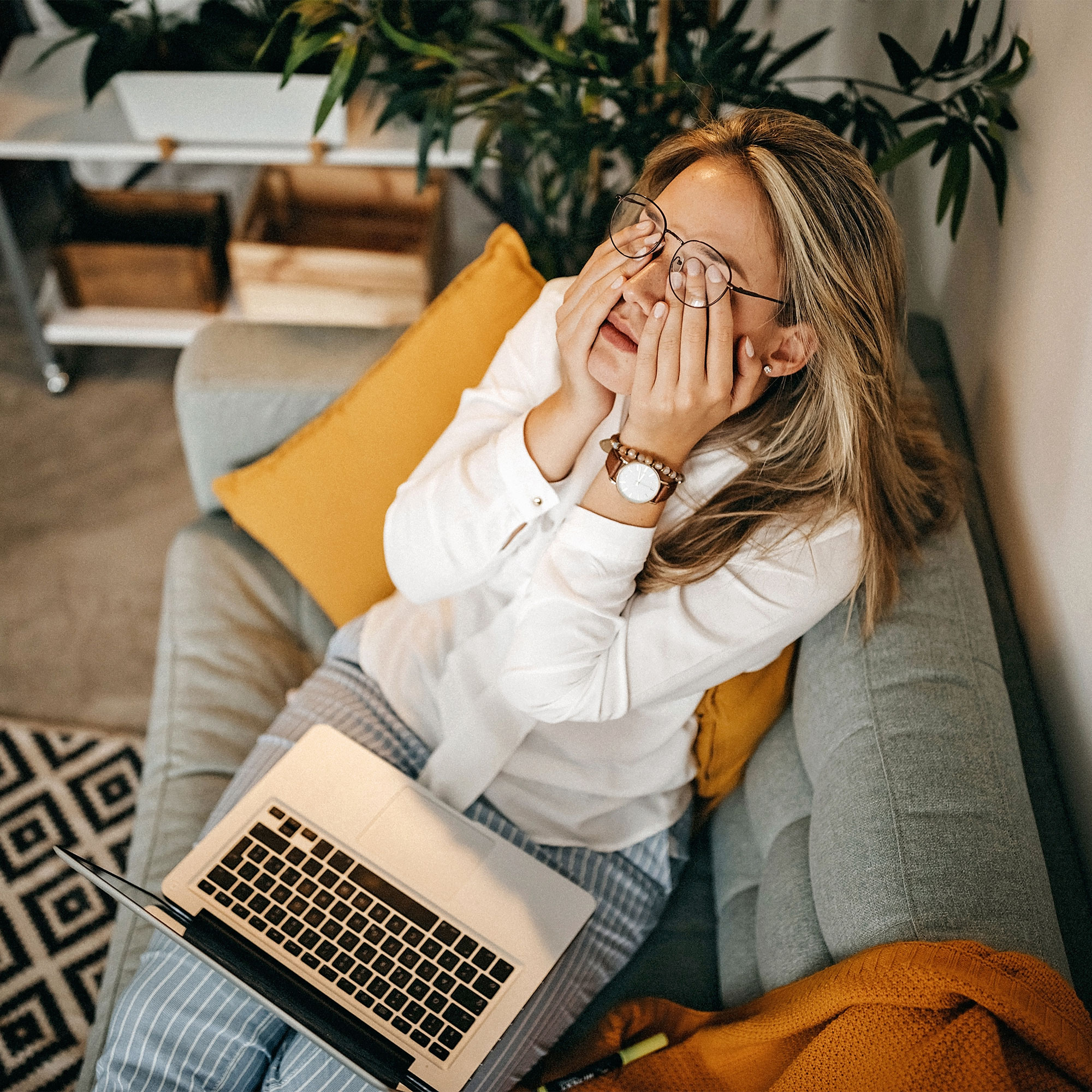 一个疲惫的女人用她的笔记本电脑在家里