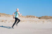 跑步在海滩的妇女在她的癌症治疗期间。