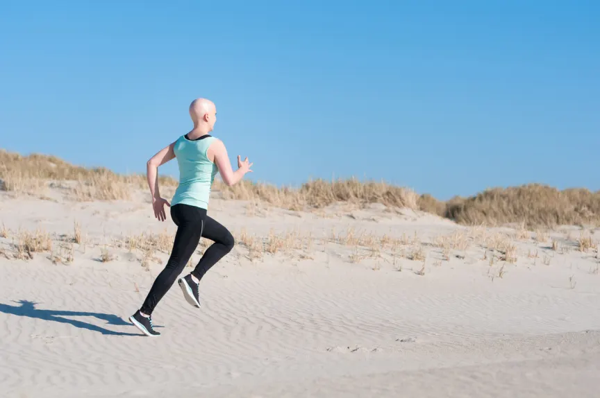 癌症治疗期间，一名女子在沙滩上慢跑。