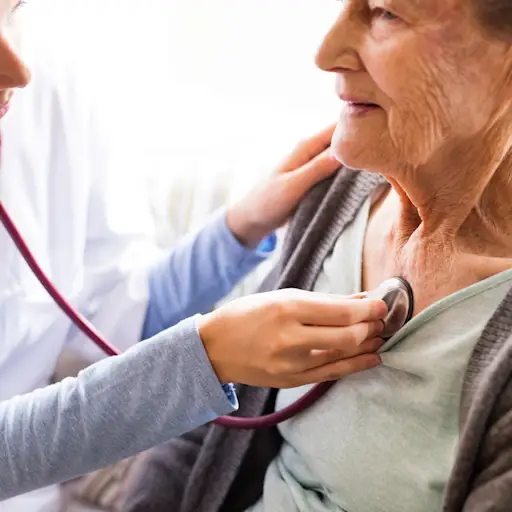 医生用听诊器听老年病人的心脏