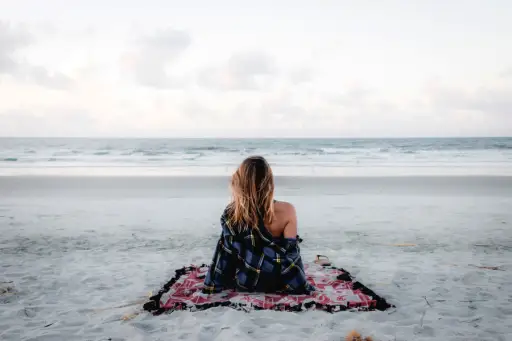 女人一个人坐在海滩上看海洋