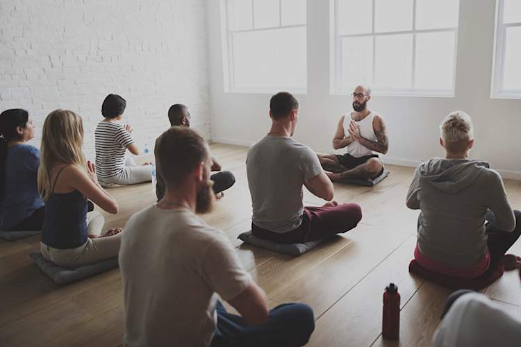 Instructor leading a mindfulness class in a meditation exercise