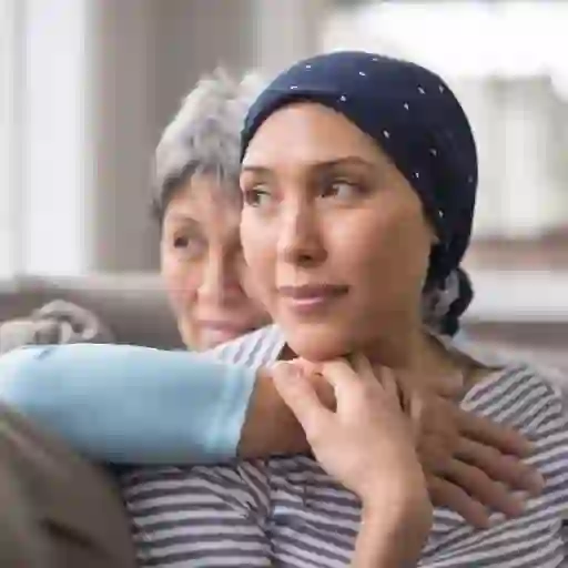 一个癌症患者和她的母亲一起坐在沙发上