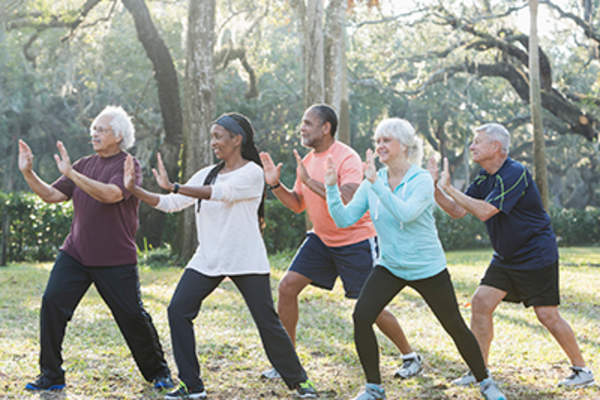 太极班的老年人在公园练习。