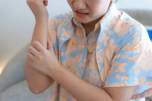 A woman scratches her forearm