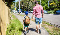 父亲走路的孩子上学。