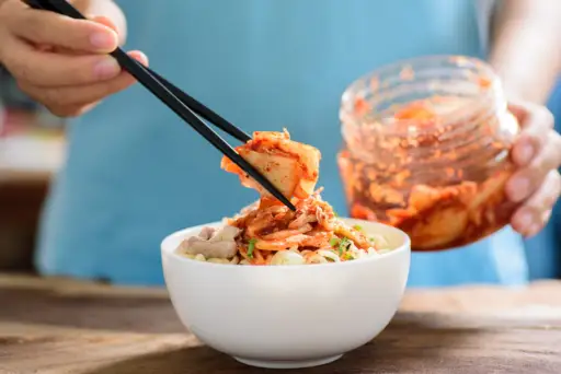 用筷子夹泡菜放在面条上的特写镜头