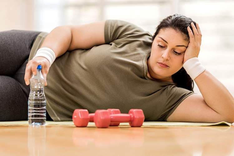 超重妇女在运动期间与重量休息。