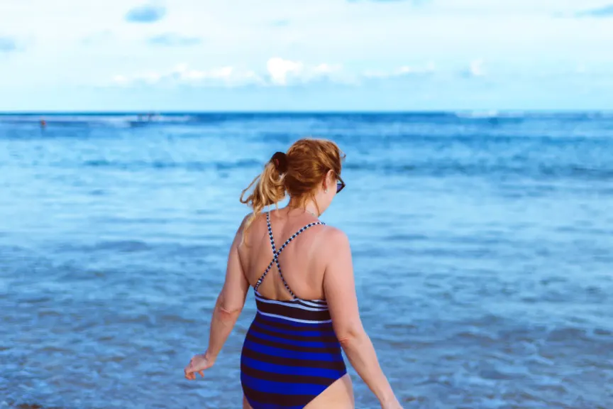 一位中年妇女穿着泳衣走进大海