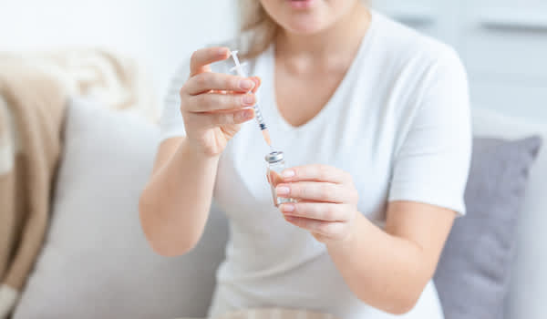 女人用生物药品填充注射器。