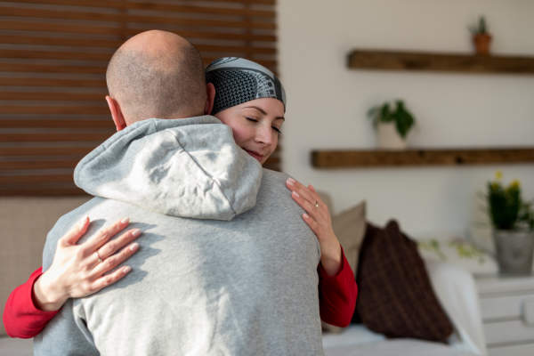 年轻的女性癌症患者拥抱她的丈夫
