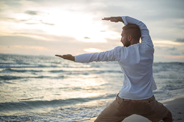 男子在海滩上做太极拳。
