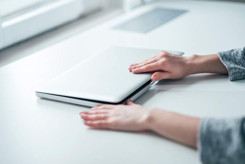 双手握住笔记本电脑