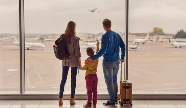 一个家庭在机场观看飞机起飞。