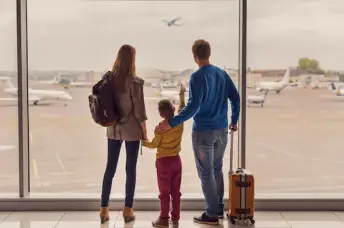 一家人在机场看着飞机起飞。