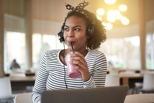 工作时喝水果冰沙的女人。