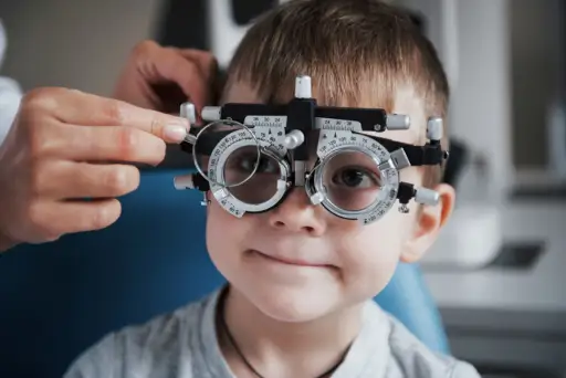 小男孩拿着荧光镜在医生的办公室里检查眼睛