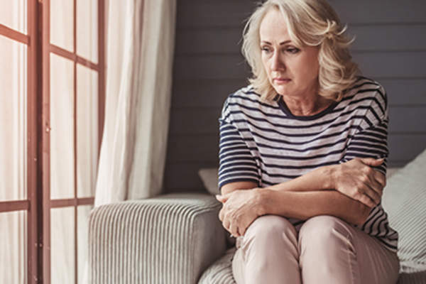 一个中年女人坐在沙发上担心。