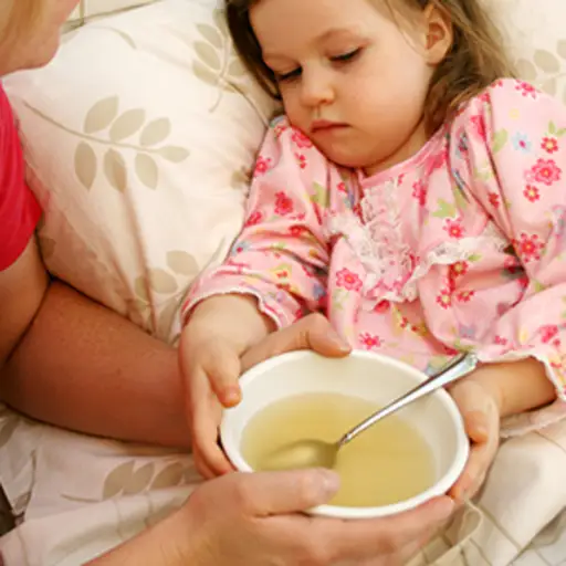 妈妈给生病的小女孩喝汤。