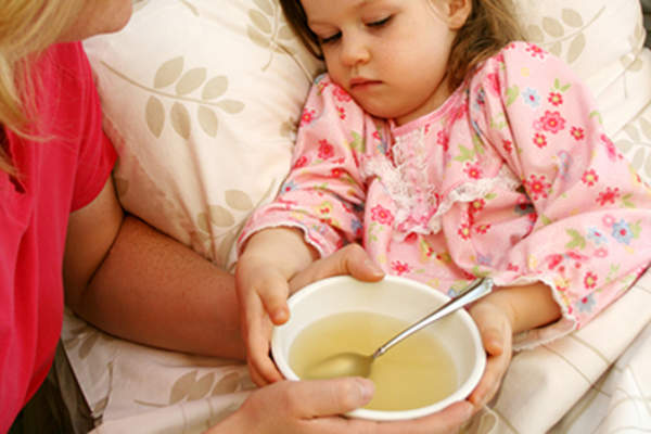 妈妈给生病的小女孩喝汤。