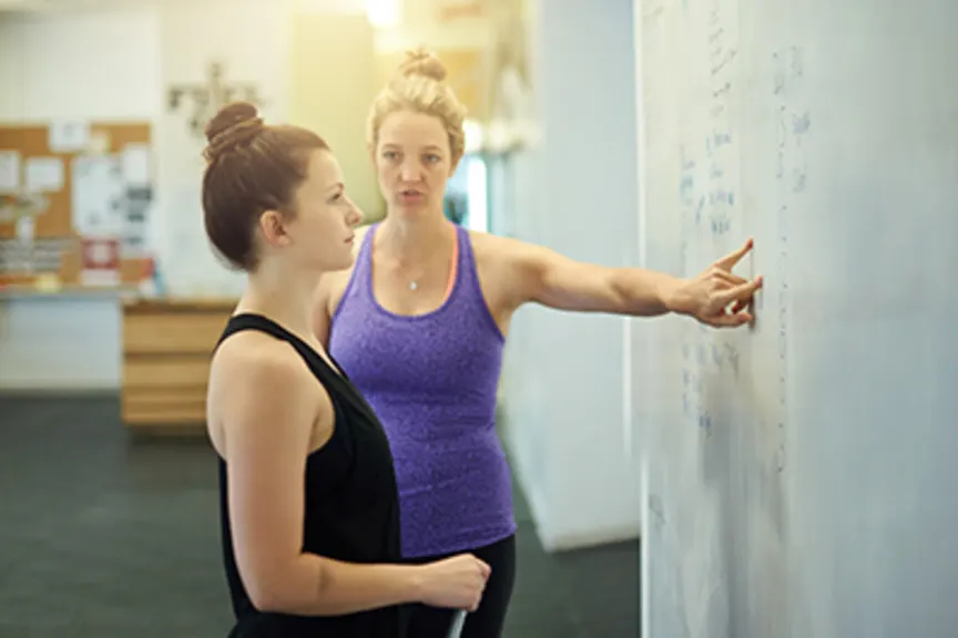 女性与教练一起制定锻炼计划。