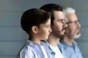 一个男孩，他的父亲和祖父站成一排