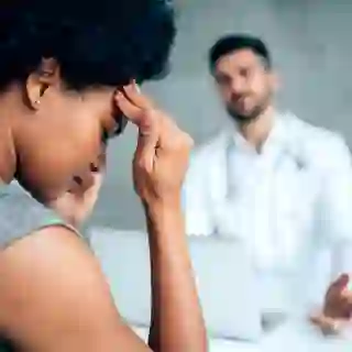 Woman with a migraine seeing a doctor