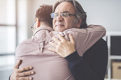 老人抱着儿子。