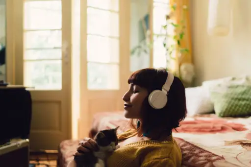戴着耳机的女孩抱着猫放松
