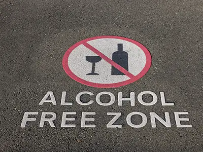 Alcohol free zone sign on pavement.