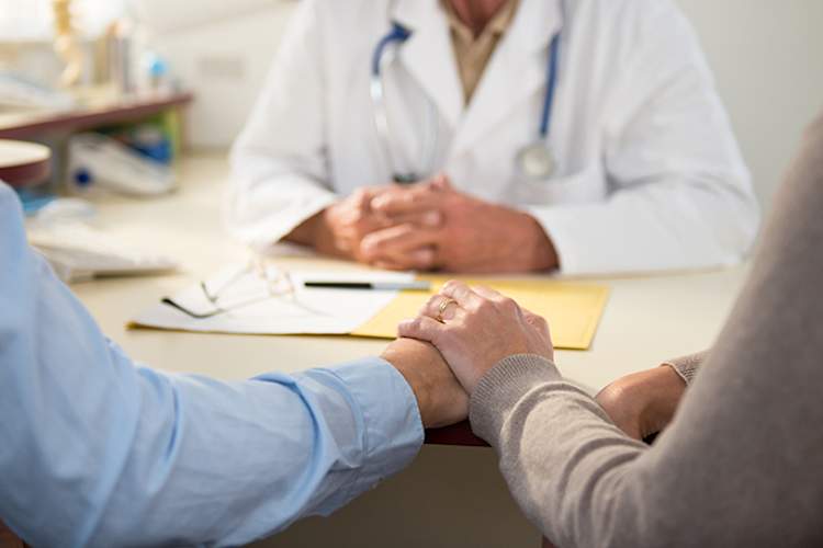 一对夫妇在看医生时手牵手。