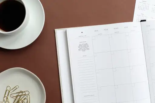 桌上放着日历，还有回形针和咖啡