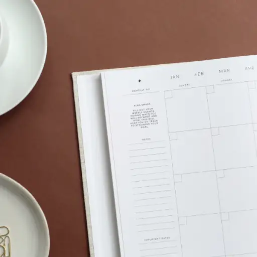 桌上放着日历，还有回形针和咖啡