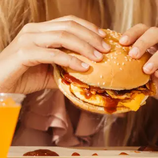 woman's hands eating burger