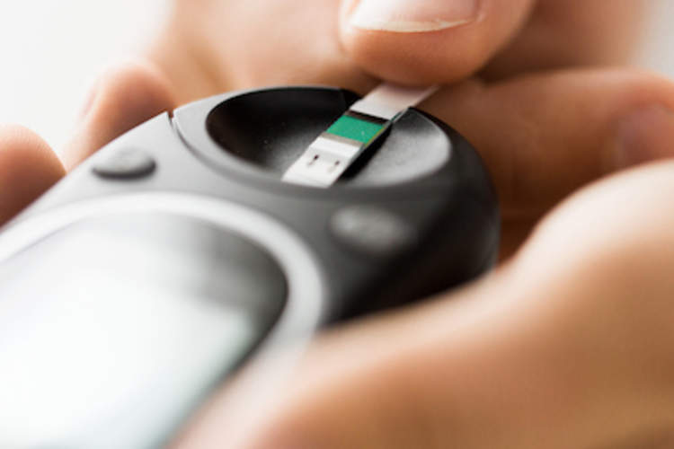 一个女人测试她的血糖使用血糖仪。