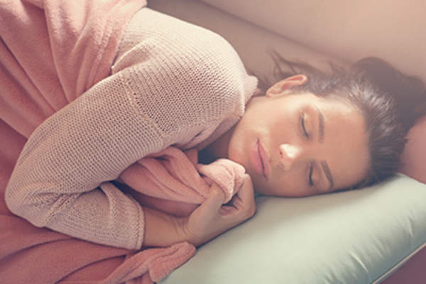 一个女人依偎在沙发上的毯子上。