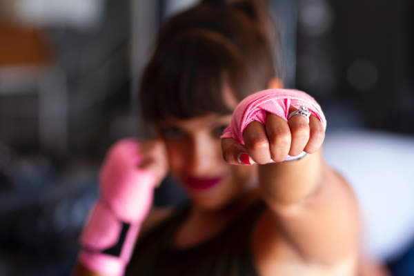 女子在拳击姿态手中的粉色胶带