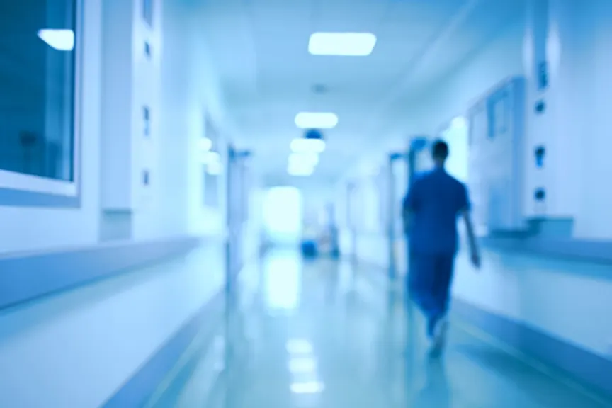 Nurse walking in hospital corridor at night.