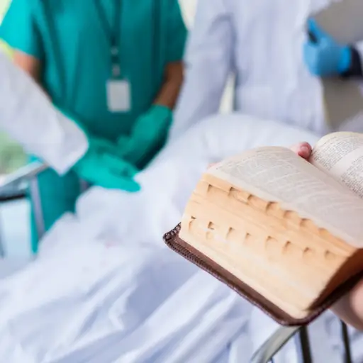 医院Chaplain阅读圣经在患者室。
