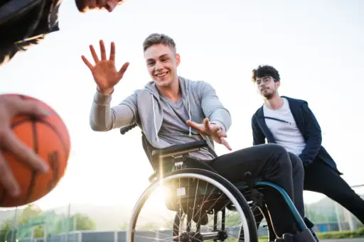 年轻人坐在轮椅上打篮球