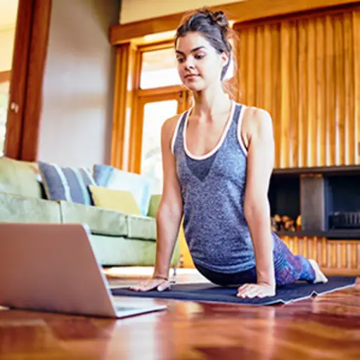 Woman looking at laptop while working out at home