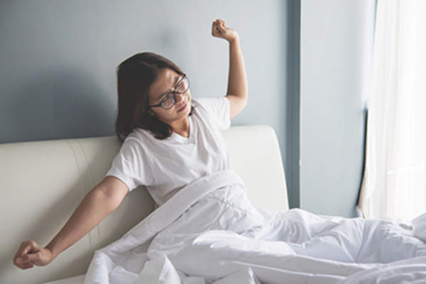 女人早上醒来,伸伸胳膊。