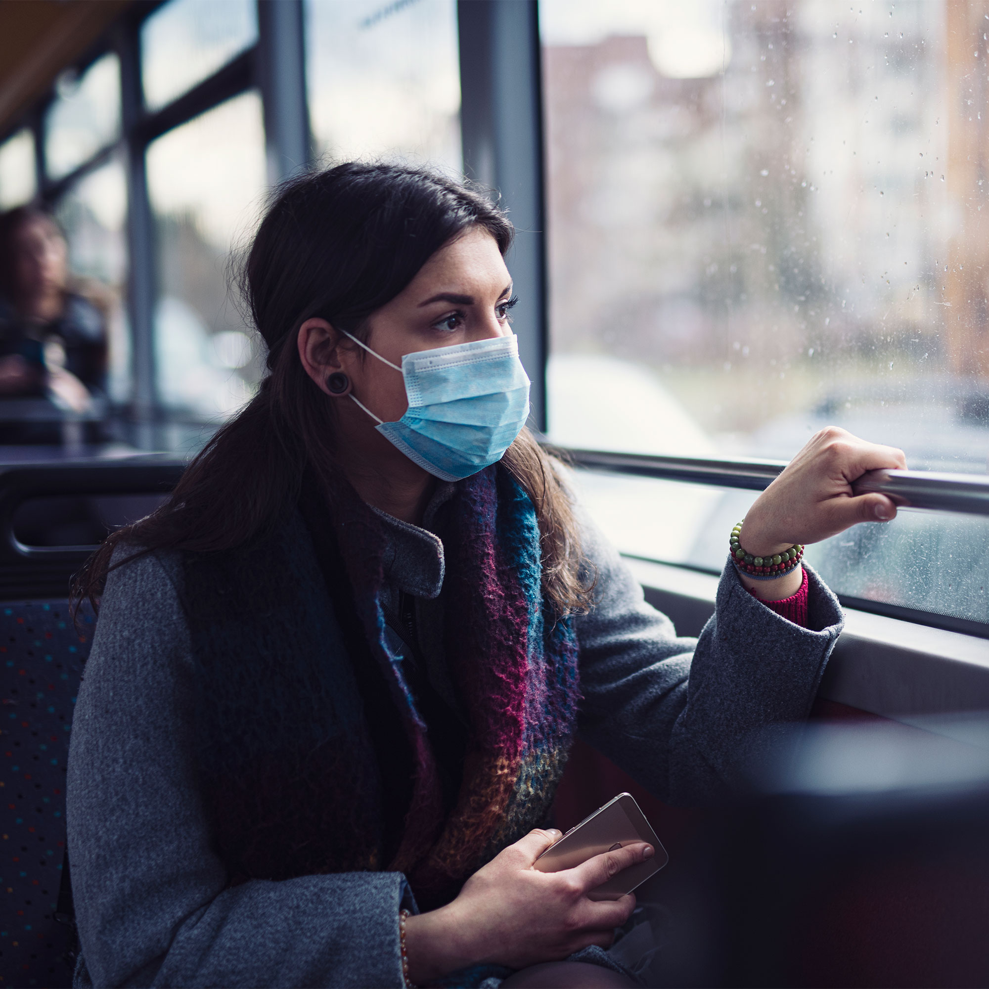 担心的女人在公共汽车上看到一个窗口