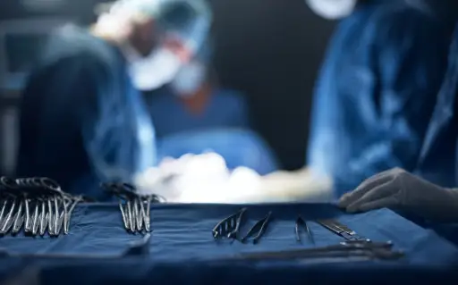 手术工具放在手术台上，背景是外科医生