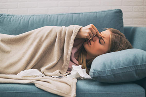 Woman experiencing RA flares caused by her cold.