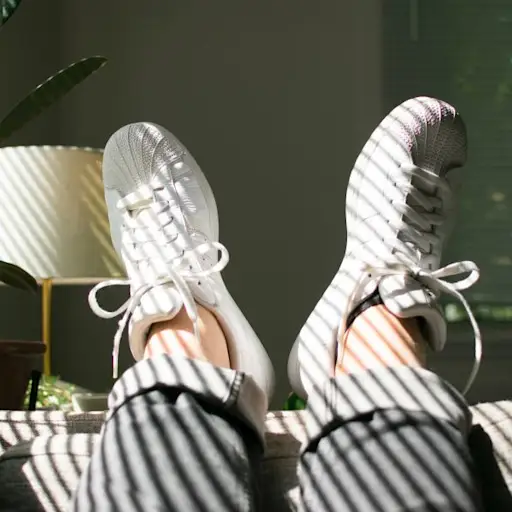 sneakers and bare ankles on couch