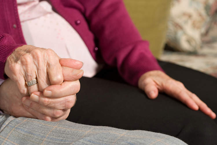 老夫妇手牵着手的特写。