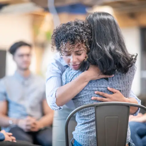 Women hugging at support group